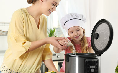 Mother and daughter making rice together with a rice cooker